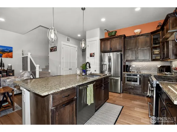a kitchen with stainless steel appliances granite countertop a sink refrigerator and cabinets