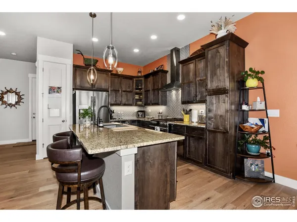 a kitchen with stainless steel appliances granite countertop a sink refrigerator and cabinets
