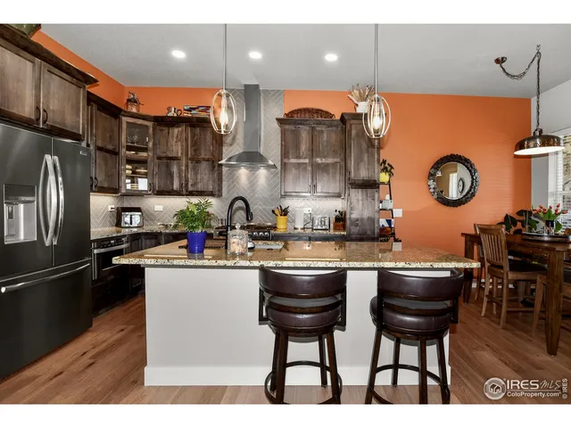 a kitchen with stainless steel appliances granite countertop a sink a stove and a refrigerator