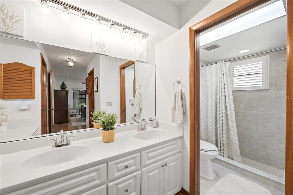 5227 Suwannee Road Weeki Wachee, FL 34607 - Photo 28 of 62 a bathroom with a sink a mirror and a shower