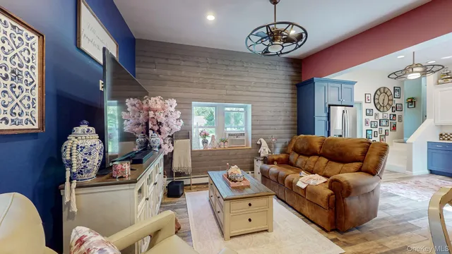 a living room with furniture flat screen tv and a large window