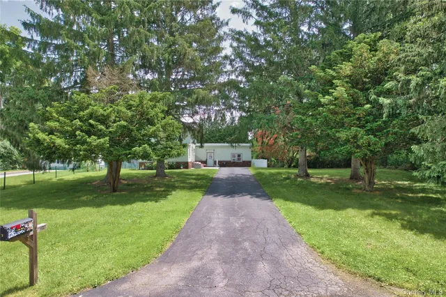 a view of a backyard with table and chairs and a tree