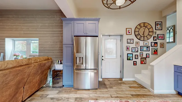 a living room with furniture a refrigerator and a window