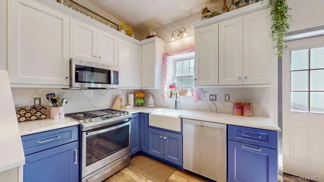 a kitchen with stainless steel appliances granite countertop a sink a stove a refrigerator and cabinets