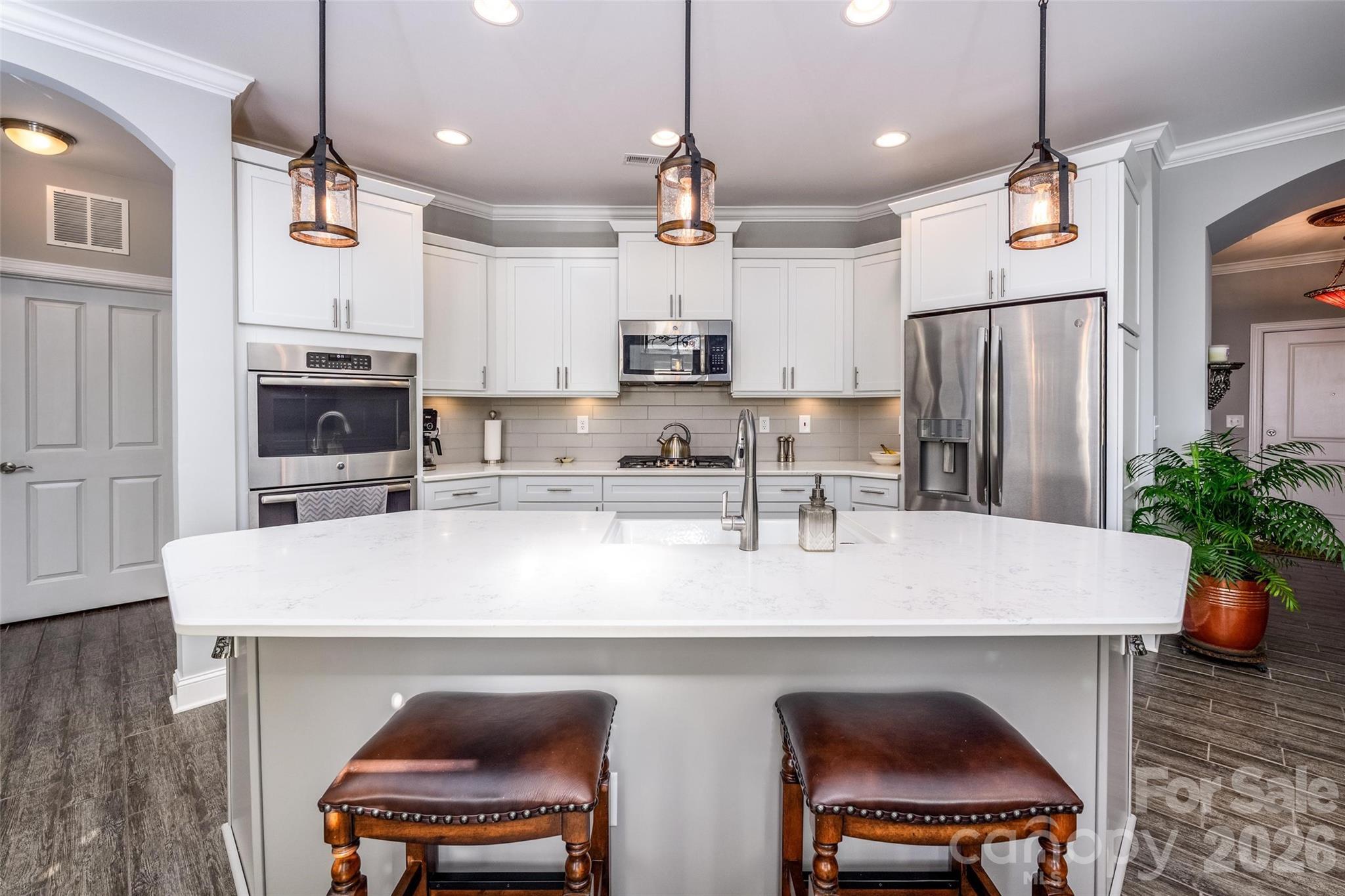 a kitchen with stainless steel appliances a table chairs refrigerator and stove