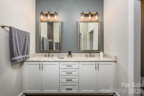 a bathroom with a double vanity sink and mirror