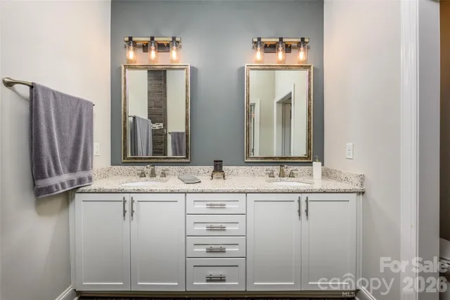 a bathroom with a double vanity sink and mirror