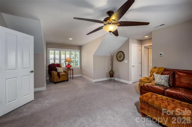 a living room with furniture and a ceiling fan