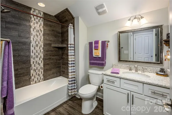 a bathroom with a toilet sink vanity tub and shower