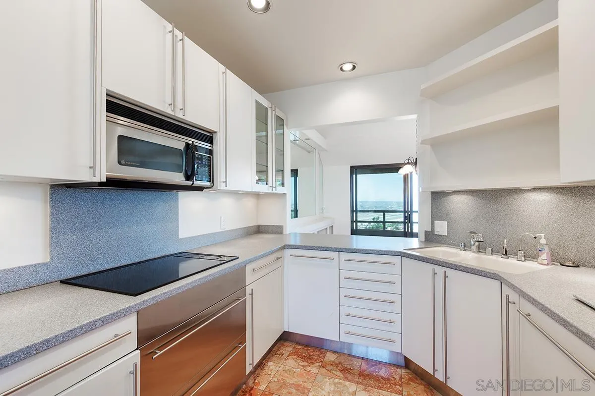 230 West Laurel Street, Unit 1001 San Diego, CA 92101 - Photo 11 of 44 a kitchen with stainless steel appliances granite countertop a sink a stove microwave and cabinets