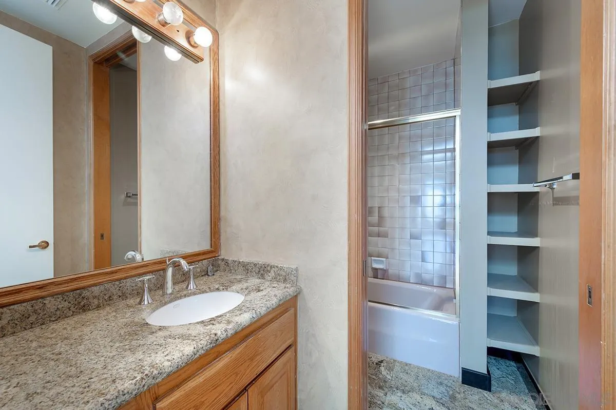 230 West Laurel Street, Unit 1001 San Diego, CA 92101 - Photo 16 of 44 a bathroom with a granite countertop sink and a mirror