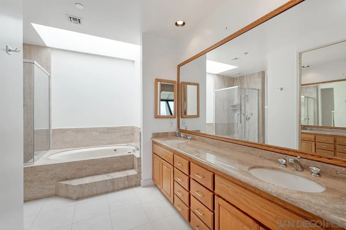230 West Laurel Street, Unit 1001 San Diego, CA 92101 - Photo 22 of 44 a spacious bathroom with a granite countertop tub sink and mirror