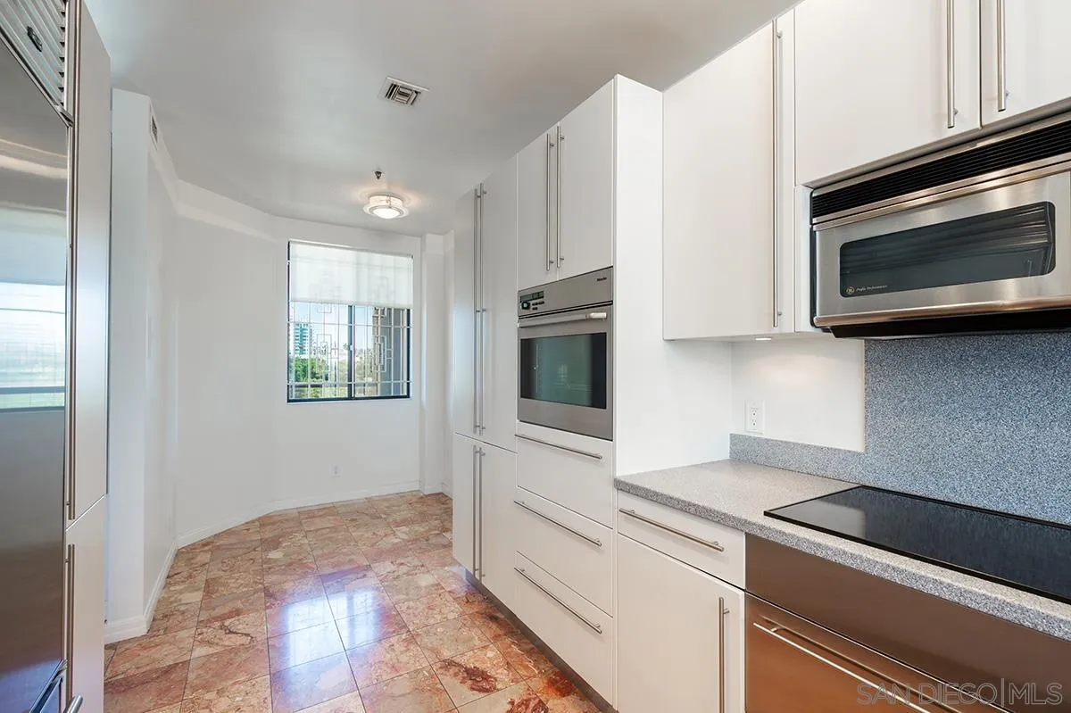230 West Laurel Street, Unit 1001 San Diego, CA 92101 - Photo 8 of 44 a kitchen with stainless steel appliances white cabinets and a stove top oven