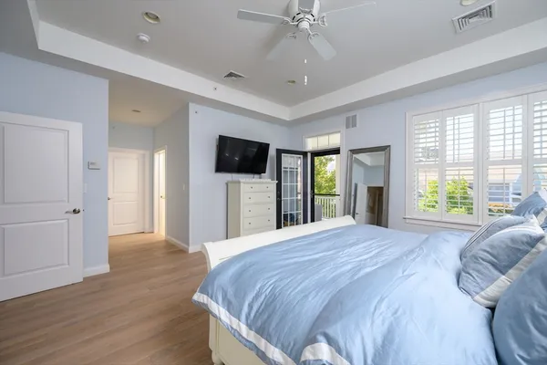 a large bedroom with a bed and wooden floor