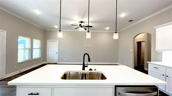 a kitchen with stainless steel appliances kitchen island a sink a stove and a wooden floor