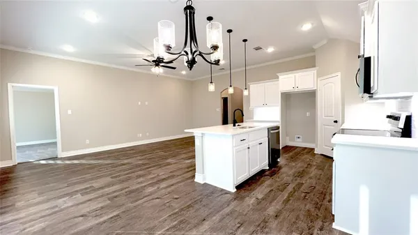 a living room with stainless steel appliances kitchen island hardwood floor and a window