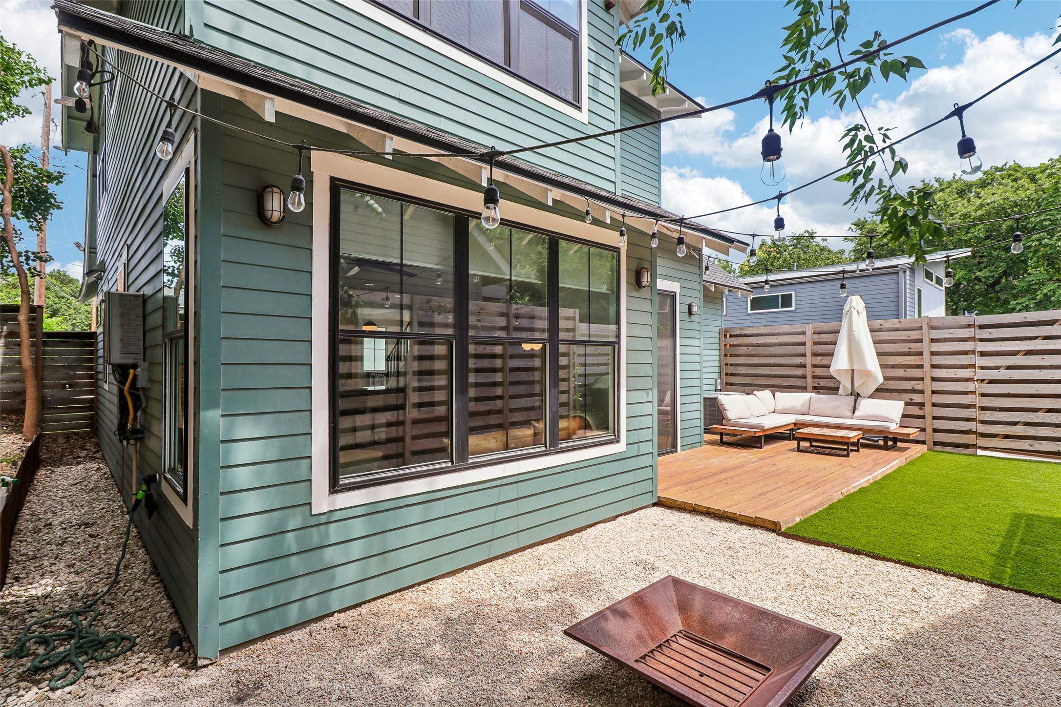 1706 Perez Street, Unit 1 Austin, TX 78721 - Photo 35 of 36 A private outdoor space features a spacious wooden deck with string lights and a fire pit.