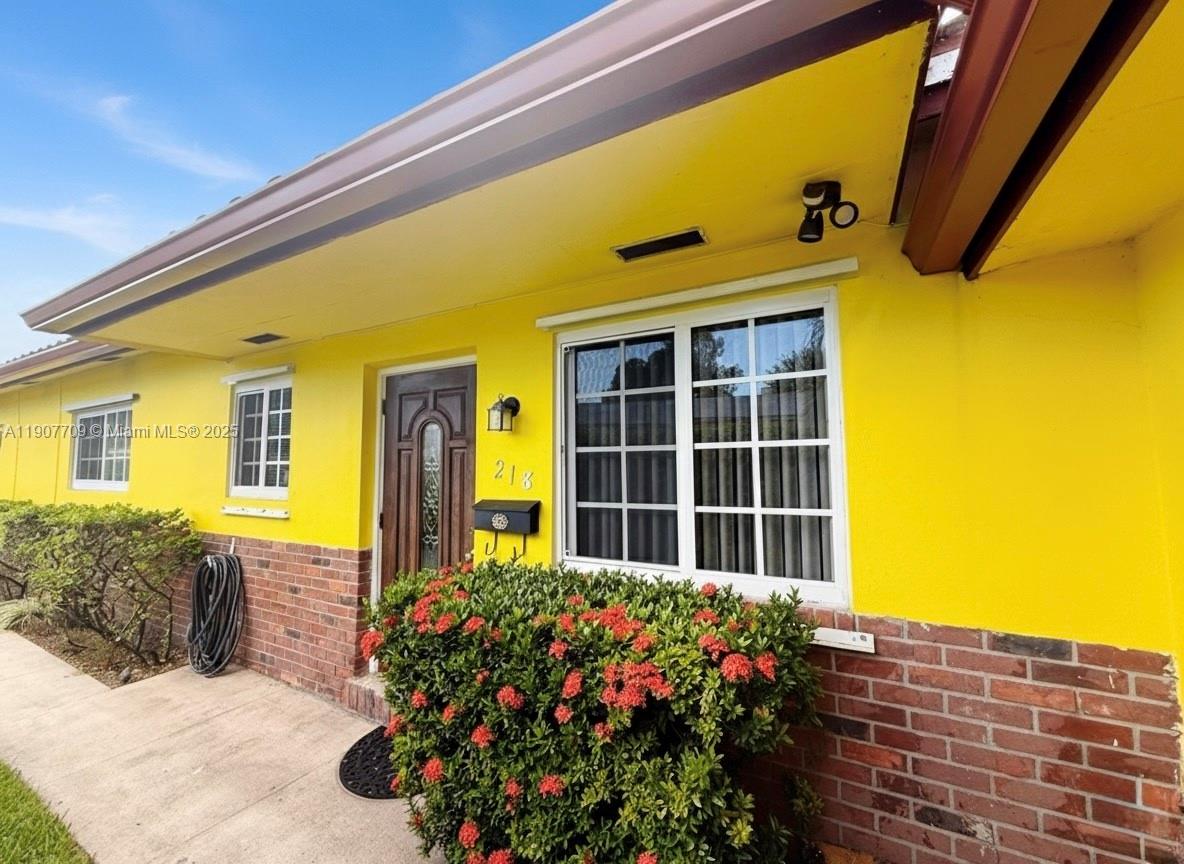 216 Southwest 10th Street, Unit 2 Hallandale Beach, FL 33009 - Photo 11 of 14 a front view of a house with a yard