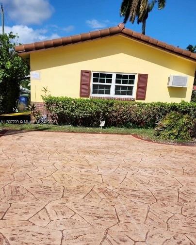 216 Southwest 10th Street, Unit 2 Hallandale Beach, FL 33009 - Photo 12 of 14 a view of yellow house with a yard