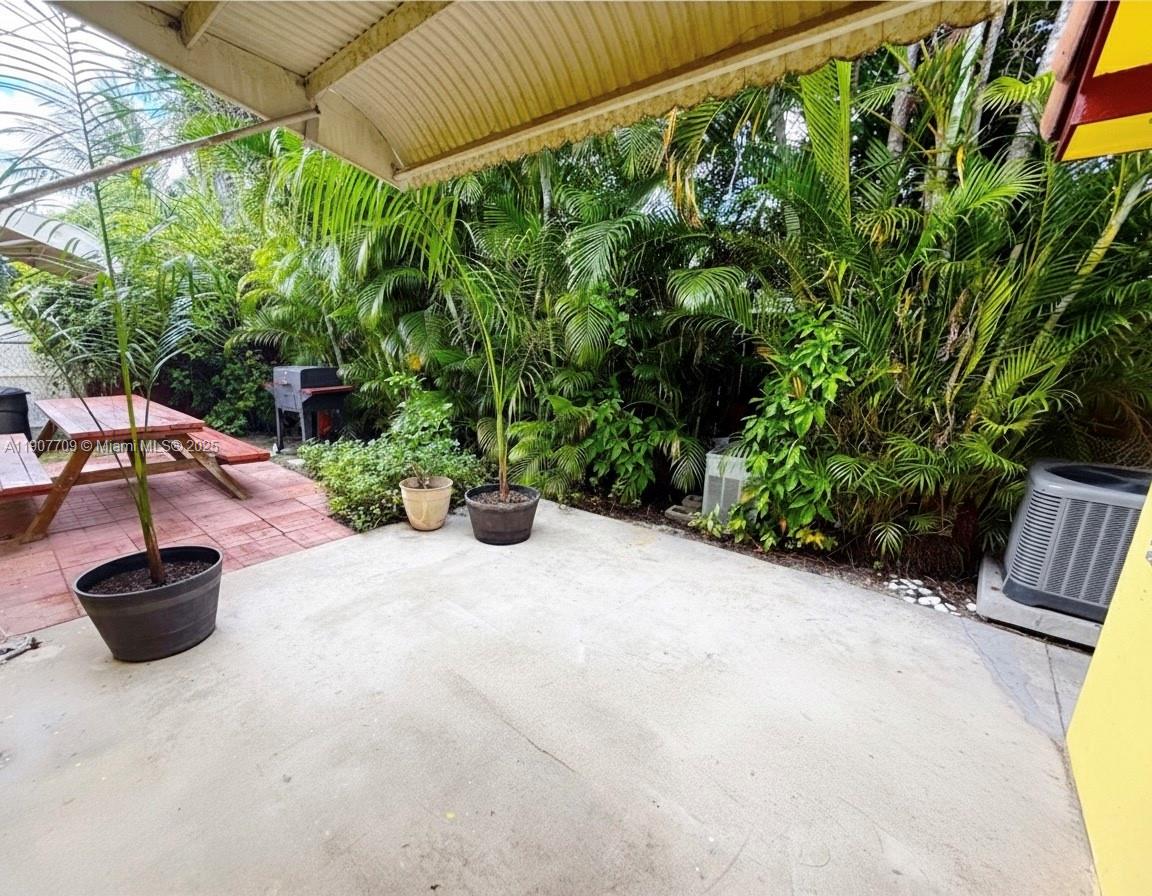 216 Southwest 10th Street, Unit 2 Hallandale Beach, FL 33009 - Photo 14 of 14 a view of a backyard with chair and potted plants