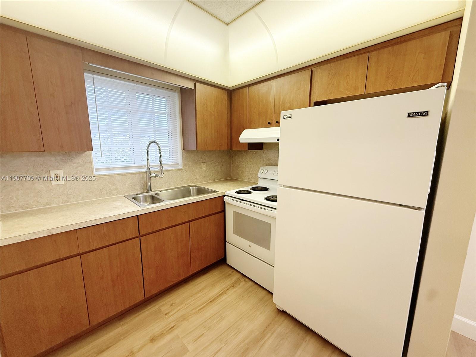 216 Southwest 10th Street, Unit 2 Hallandale Beach, FL 33009 - Photo 4 of 14 a kitchen with sink a refrigerator and a stove