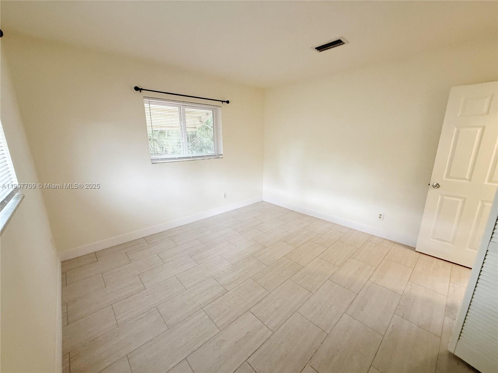 216 Southwest 10th Street, Unit 2 Hallandale Beach, FL 33009 - Photo 8 of 14 an empty room with a wooden door
