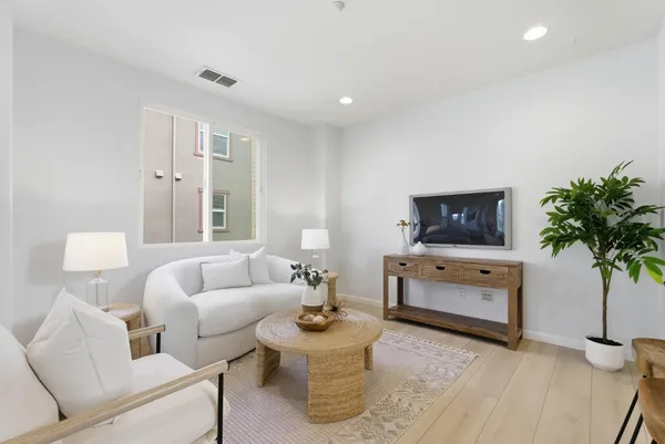 a living room with furniture a flat screen tv and a potted plant