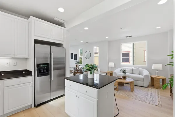 a kitchen with stainless steel appliances kitchen island granite countertop a refrigerator and a sink