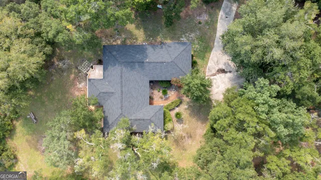 a view of an empty room with wooden floor and a ceiling fan