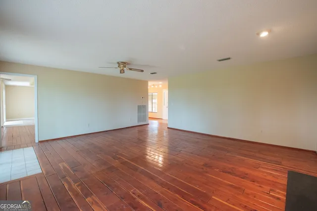 a view of a room with wooden floor closet and windows
