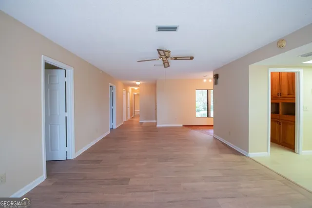 a view of an empty room and a ceiling fan window