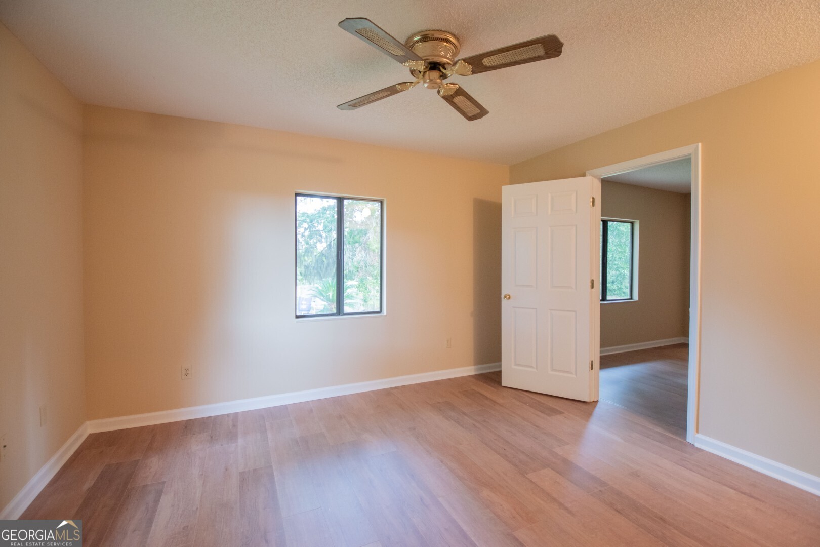 1924 Cedar Court Waverly, GA 31565 - Photo 38 of 78 an empty room with wooden floor ceiling fan and windows