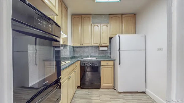a kitchen with a refrigerator a stove and cabinets