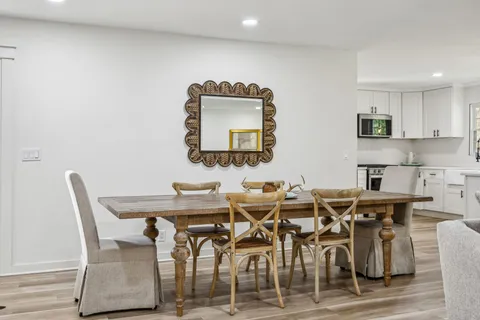 a kitchen with stainless steel appliances kitchen island granite countertop a sink a counter space and living room view