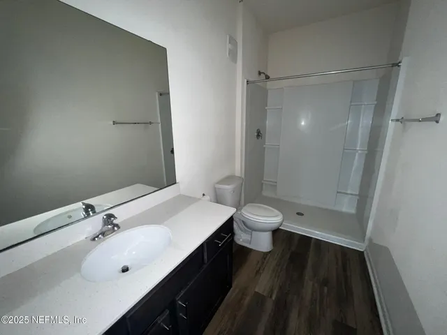 a bathroom with a sink a toilet and shower