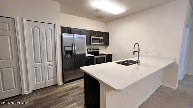a kitchen with a sink a refrigerator and cabinets