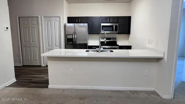 a kitchen with kitchen island granite countertop cabinets and refrigerator