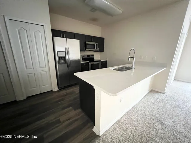 a kitchen with stainless steel appliances a refrigerator and a sink