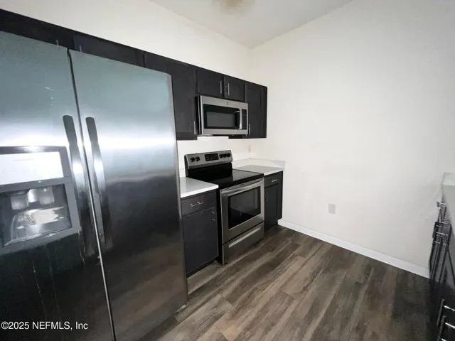 a kitchen with stainless steel appliances granite countertop a refrigerator and a sink