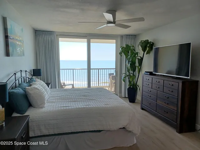 a bedroom with a bed table and flat screen tv