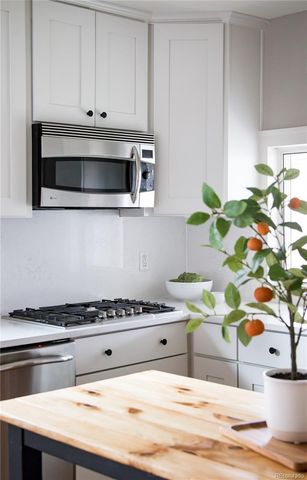 a kitchen with a stove and white cabinets