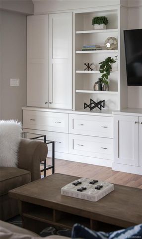 a living room with white cabinets and flat screen tv