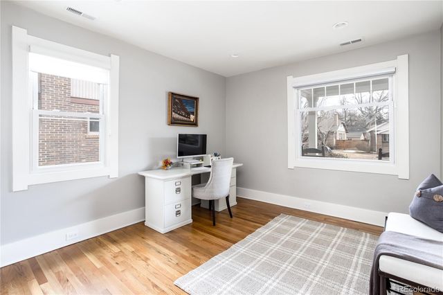 a view of a workspace with wooden floor and a window