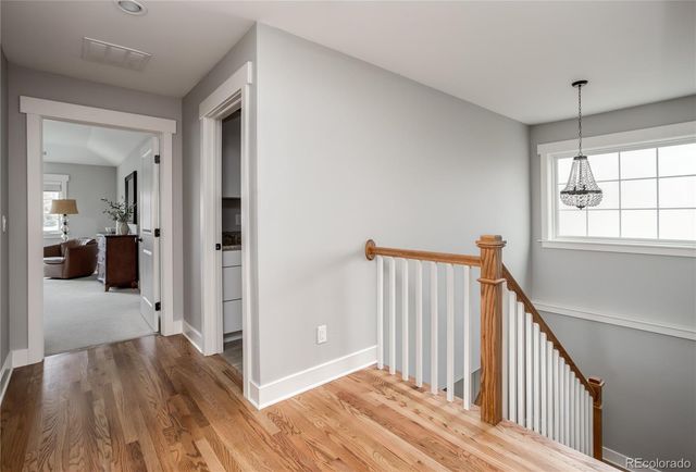a view of a hallway with wooden floor and staircase