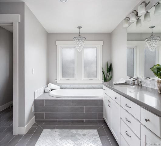 a bathroom with a tub sink and mirror