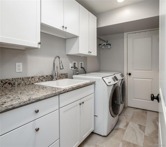 a utility room with sink dryer and washer