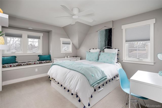 a spacious bedroom with a large bed and a chandelier