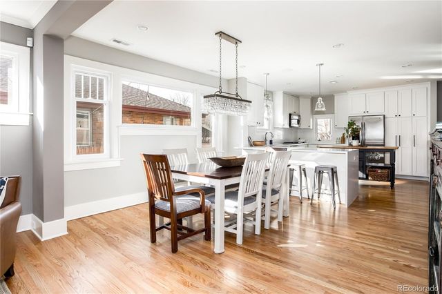 a dining room with furniture a chandelier and wooden floor