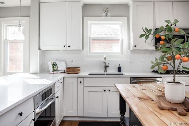 a kitchen with white cabinets and window