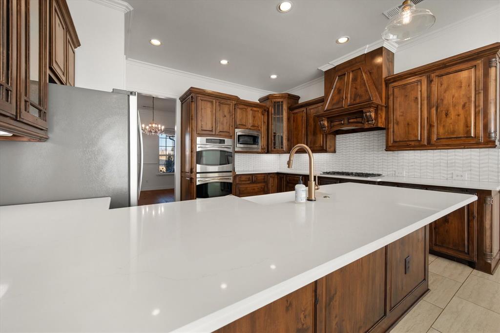 6056 Bennett Lawson Road Mansfield, TX 76063 - Photo 20 of 38 a large kitchen with stainless steel appliances a large counter top a oven a sink and a refrigerator